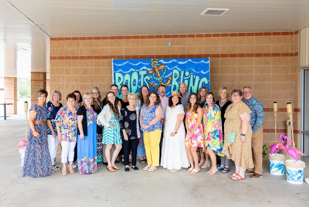 Kansas State Fair Fairboard members smiling and engaging with guests at the Boots and Bling event, dressed in formal attire and participating in the festivities