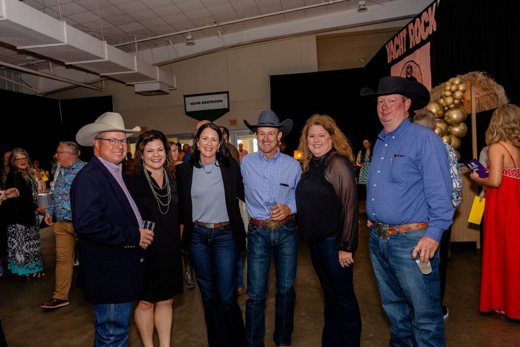 Guests enjoying the Boots and Bling event inside the 1861 Building, with tables, decor, and event activities visible in the background.