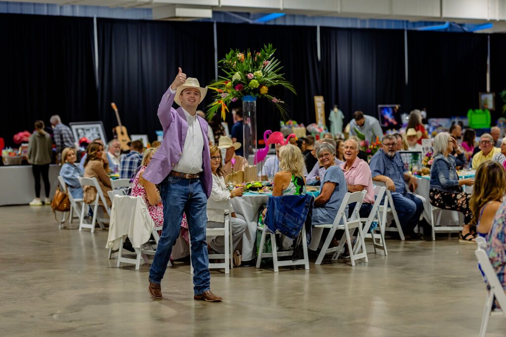 Auction staff at the Boots and Bling event, assisting guests with bidding and showcasing items at the silent auction tables.