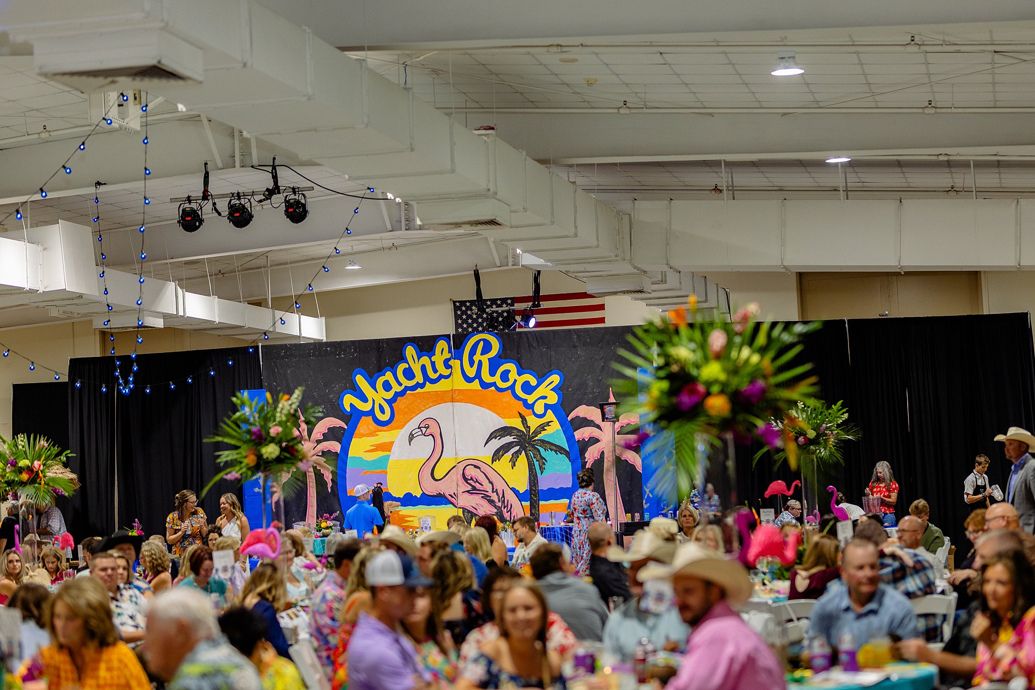 Attendees participating in the live auction at Boots and Bling, bidding on various items with excitement.